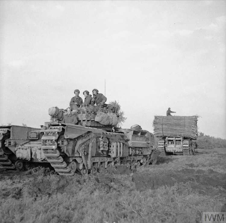 Churchill AVRE towing a sled with fascines, and another carrying a fascine, moving up for 53rd Division's attack west of Oss in Holland, 23 October 1944. Imperial War Museum