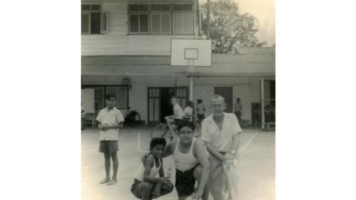 "Basketballen op de speelplaats", Curaçao (jaartal onbekend). De foto was bedoeld om de vriendschappelijke relatie tussen kind en frater te laten zien. (Bron: collectie Fraters van Tilburg / Stadsmuseum Tilburg inv. nr. 409947)