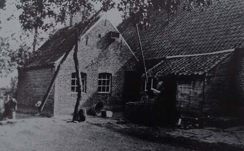 Bet van de Laar schept water achter haar huis in Hezelaar. (Foto: Collectie Erfgoedvereniging Kèk Liemt)